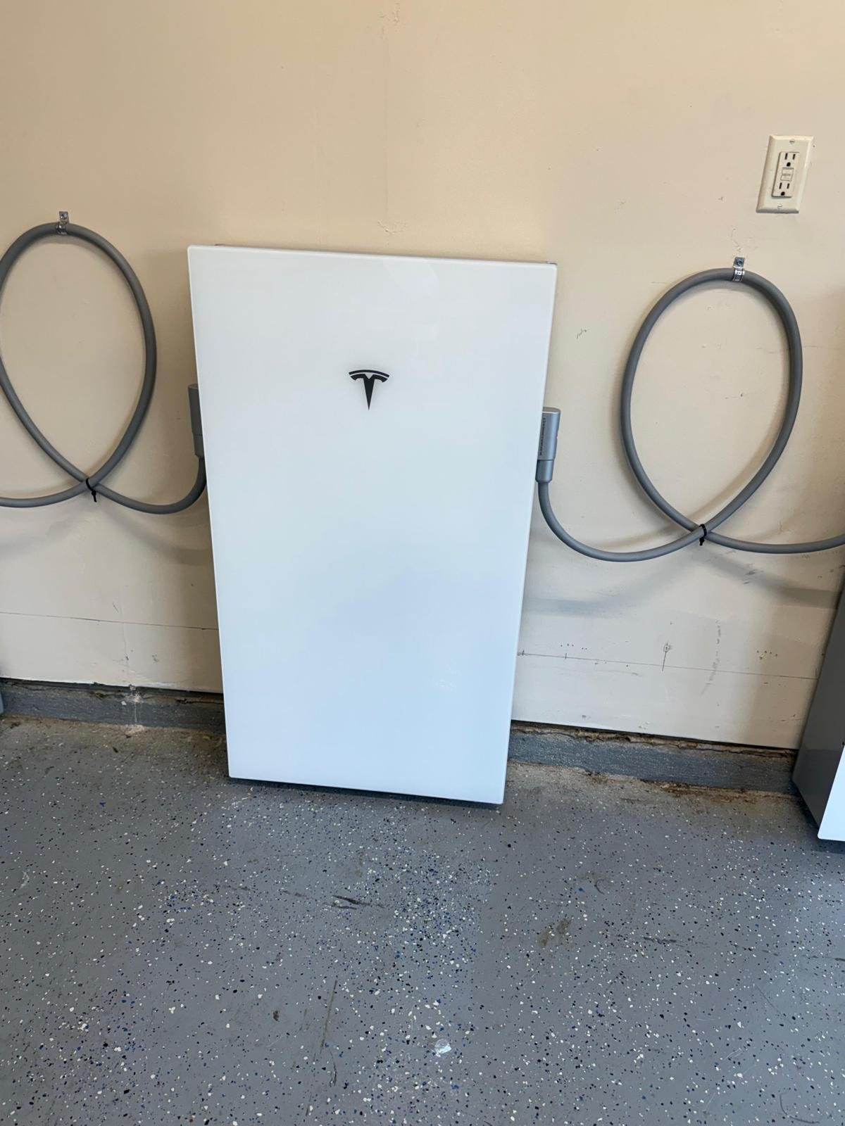 Close-up of a Tesla Powerwall 3 with neatly looped conduit entering each side